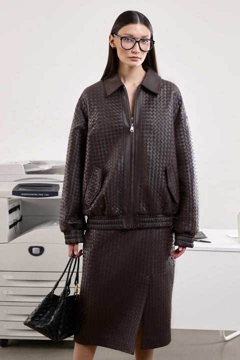 A woman models a deep brown bomber jacket designed for effortless layering, showcasing a relaxed fit and chic silhouette perfect for daily wear.